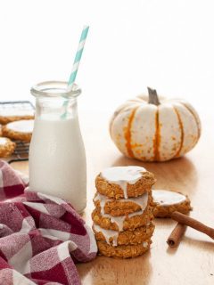gluten-free-dairy-free-iced-pumpkin-oatmeal-cookies-stacked-by-milk-and-a-mini-pumpkin
