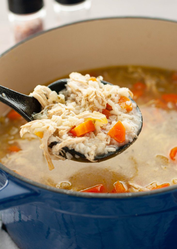easy-gluten-and-dairy-free-chicken-and-rice-soup-being-ladeled-out-of-a-dutch-oven