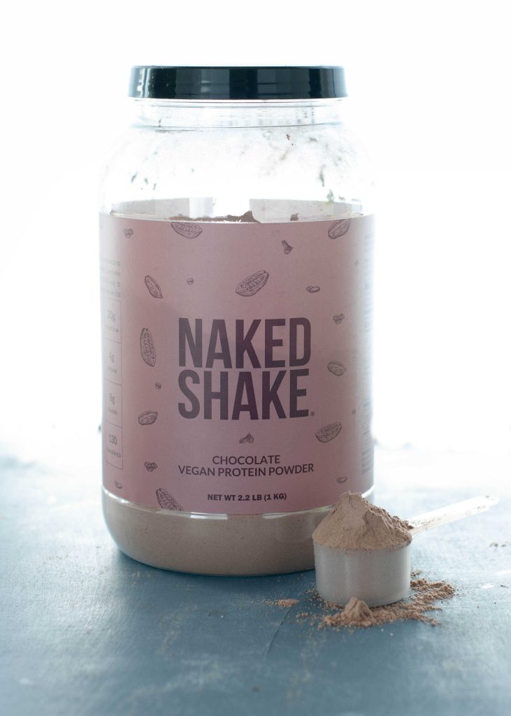 jar-of-naked-nutrition-protein-powder-with-a -scoop-of-protein-sitting-next-to-it