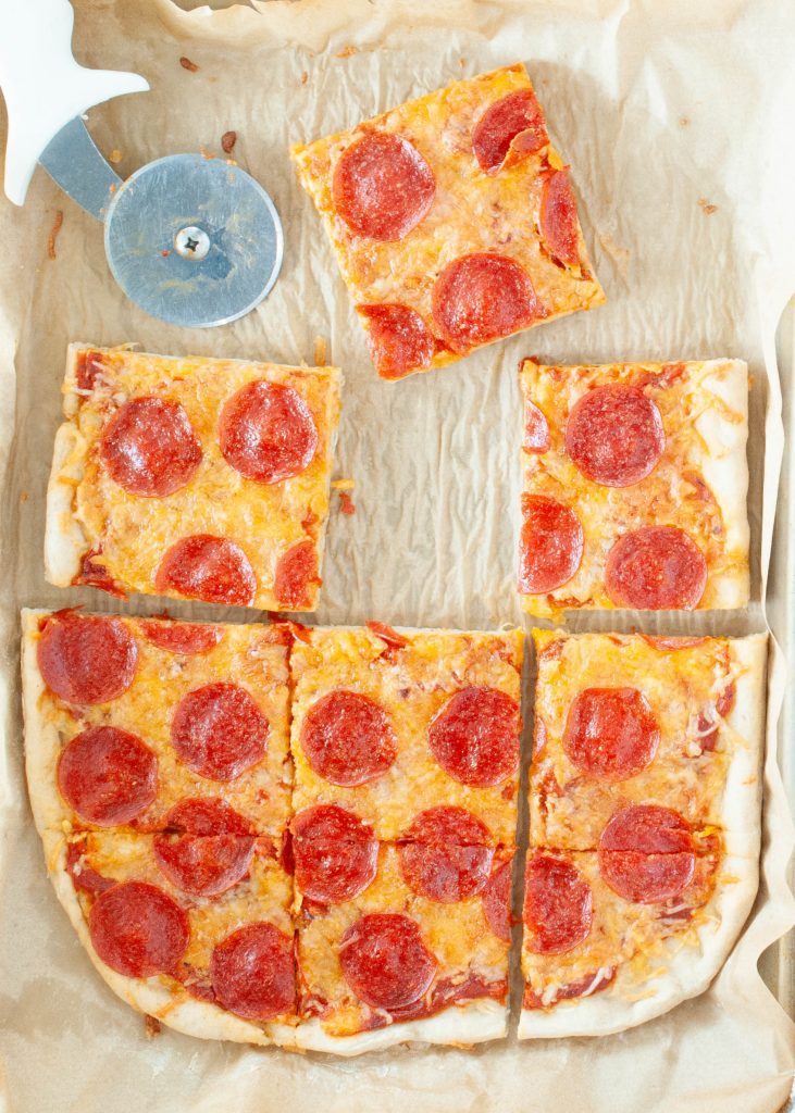 chewy-gluten-free-pizza-crust-recipe-shaped-in-a-rectangle-shown-from-above-with-slice-missing