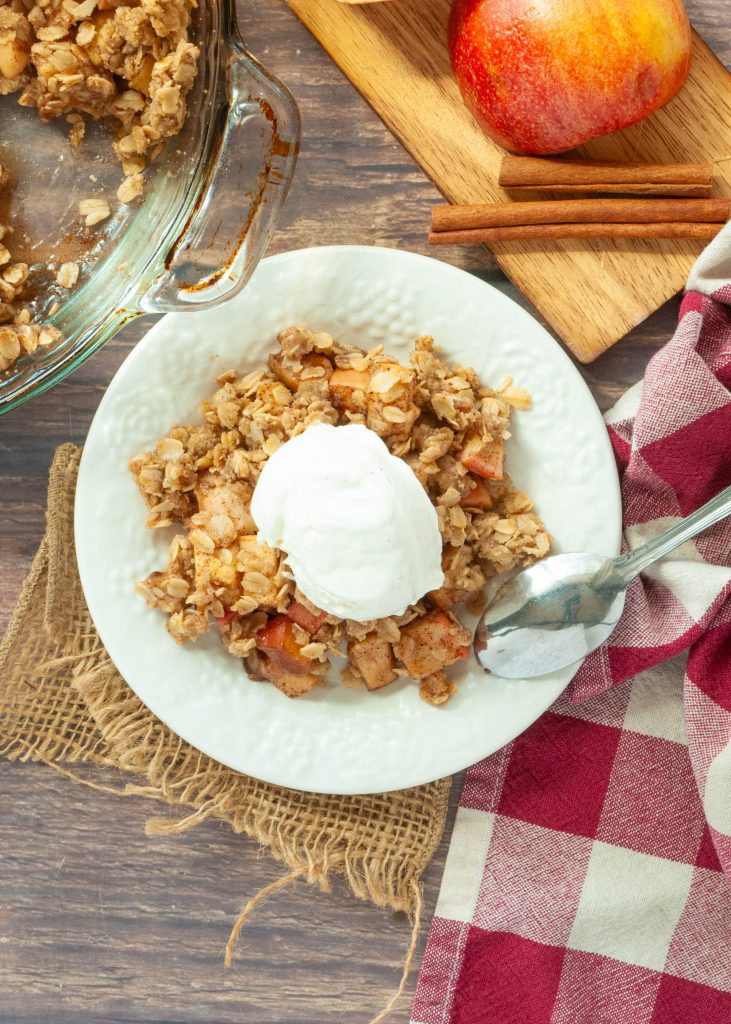 gluten-free-apple-crisp-with-vanilla-ice-cream-on-top-from-above-on-a-white-plate