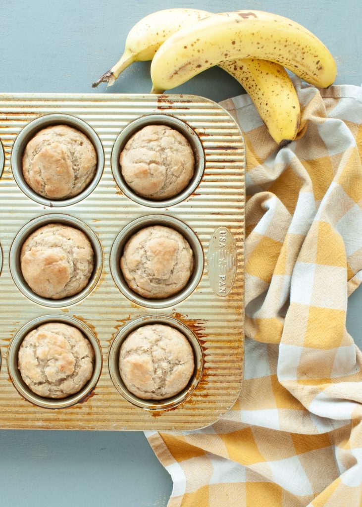6-gluten-free-banana-muffins-in-a-muffin-tin-from-above-with-bananas