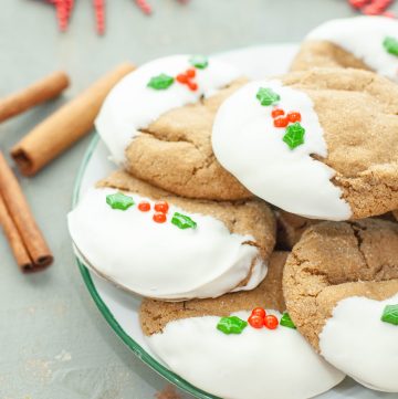 gluten-free-gingerbread-cookies-dipped-in-white-chocolate-stacked-on-a-white-plate
